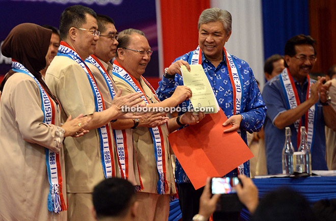 Pairin receiving the certificate and letter from Ahmad Zahid witnessed by Musa and PBS deputy presidents Datuk Seri Panglima Dr Maximus Ongkili Senator Datuk Jamilah Sulaiman and Datuk Dr Yee Moh Chai