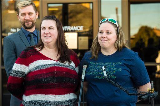 Equality Utah Executive Director Troy Williams left April Hoagland center Beckie Peirce smile during a press conference outside of the Juvenile Court in Price Utah Friday Nov. 13 2015. The married same-sex couple said Friday they are relieved after