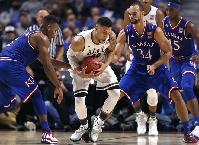 Kansas guard Wayne Selden Jr. left and forward Perry Ellis guard Michigan State guard Denzel Valentine during the first half of an NCAA college basketball game on Tuesday Nov. 17 2015. Michigan State forward Javon Bess