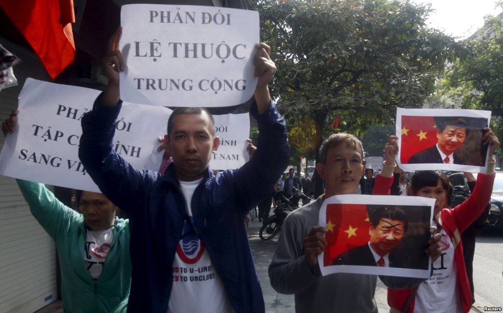 Protesters hold marked images of Chinese President Xi Jinping and anti China signs during a protest ahead of his visit to Vietnam on the street in Hanoi Nov. 3 2015