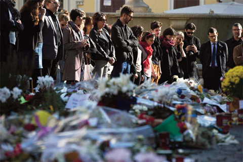 ROME People mourn during a Europe-wide minute of silence to honor the victims of the terror attacks in Paris in front of the French Embassy in Rome yesterday. — AP