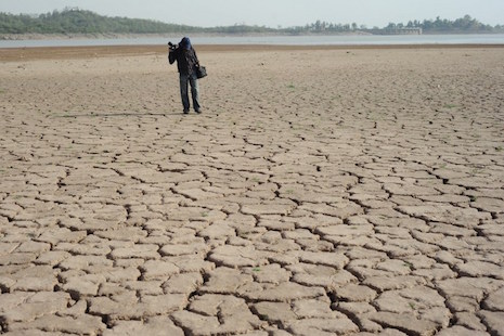 A Pakistani man stands on a dry portion of the Rawal Dam in Islamabad. Church groups across the region are urging world leaders to take action during the Paris climate change conference starting Nov. 30