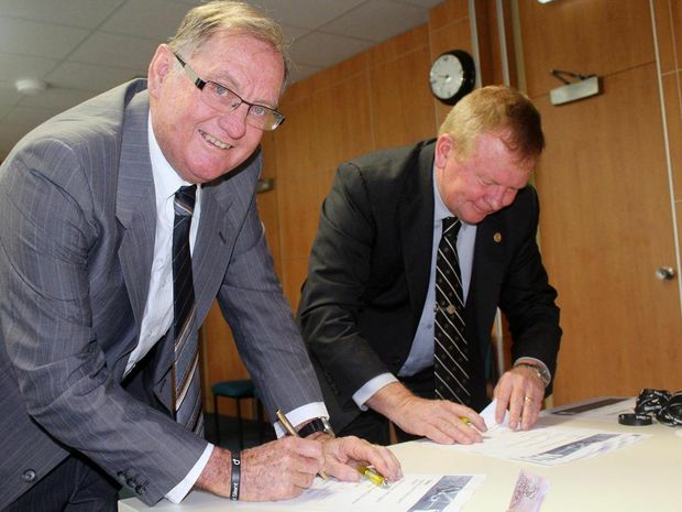 Deputy Mayor Cr Kevin Casey and Cr Frank Gilbert sign the pledge against domestic violence on White Ribbon Day