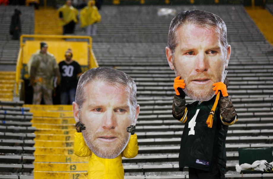 Fans hold up former Green Bay Packers quarterback Brett Favre masks before an NFL football game between the Green Bay Packers and the Chicago Bears Thursday Nov. 26 2015 in Green Bay Wis. Favre is being honored during a ceremony at halftime