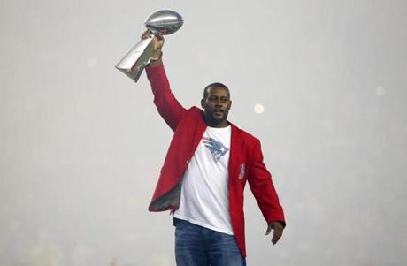 Former New England Patriots cornerback Ty Law raises one of the four Lombardi Trophies before an NFL football game between the New England Patriots and the Pittsburgh Steelers Thursday Sept. 10 2015 in Foxborough Mass