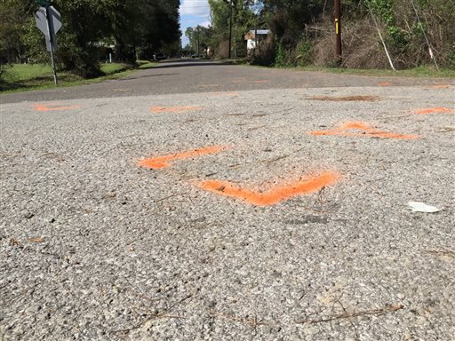 This Wednesday Nov. 4 2015 image shows orange paint marking the spot where a 6-year-old boy was shot and killed Tuesday night by Ward 2 city marshals in Marksville La. The marshals had been chasing a vehicle driven by the boys father Chris Few. He