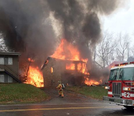 A firefighter walks up a driveway as