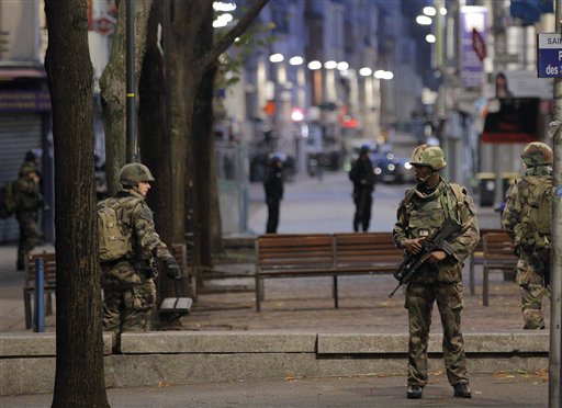 Soldiers patrol in St. Denis a northern suburb of Paris Wednesday Nov. 18 2015. Authorities in the Paris suburb of St. Denis are telling residents to stay inside during a large police operation near France's national stadium that two officials