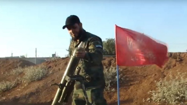 A Turkmen fighter loads a mortar while fighting Syrian government forces