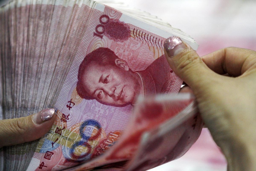 A bank clerk counts Chinese currency notes at a bank outlet in Huaibei in central China's Anhui province. ASSOCIATED PRESS