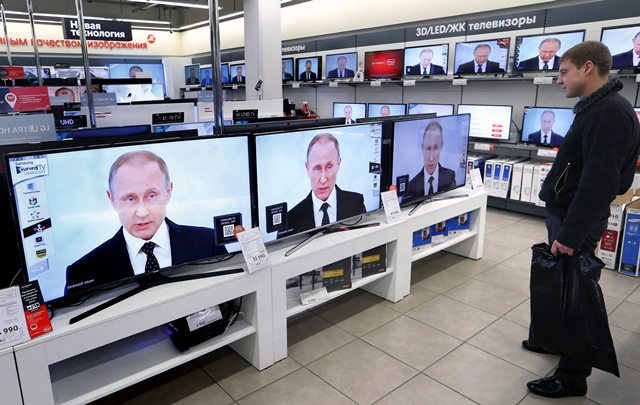 A costumer in a electronics shop watch Russian President Vladimir Putin on the TV screens in Moscow Russia 03 December 2015