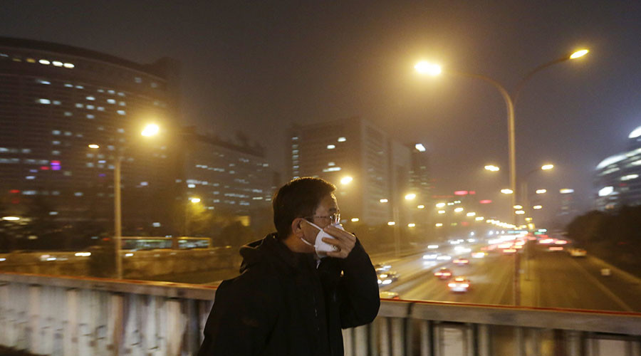 A man adjusts his protective mask amid the heavy smog in Beijing China