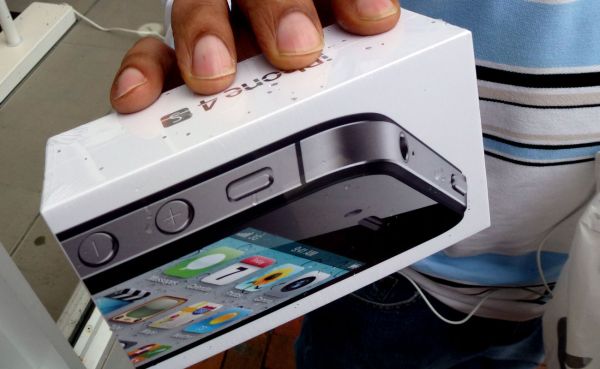A man holds his new iPhone 4S outside