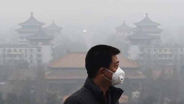 A man wears a mask after a red alert for air pollution was issued in Beijing Dec.8 2015