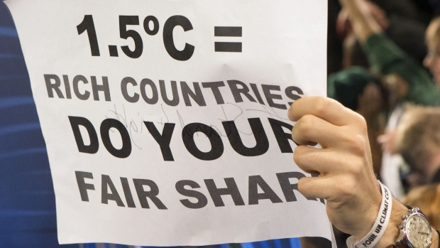 A poster held up during a protest by activists at the Paris climate talks