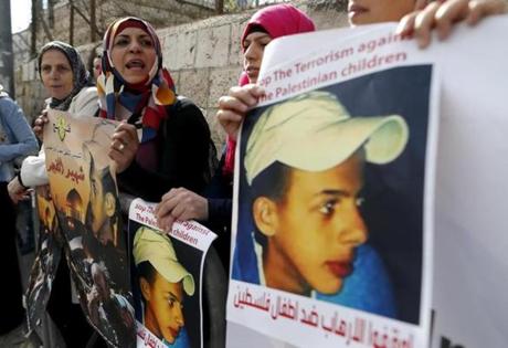 Palestinians protested on Monday outside the Jerusalem District Court holding posters showing the slain 16-year-old