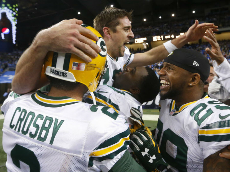 Green Bay Packers quarterback Aaron Rodgers is congratulated by teammates after his 61-yard touchdown pass to tight end Richard Rodgers on the last play of the game stunned the Lions 27-23 on Thursday night in Detroit