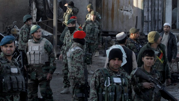 Afghan security forces inspect the damage after clashes between Taliban fighters and Afghan forces at Kandahar airport on Wednesday