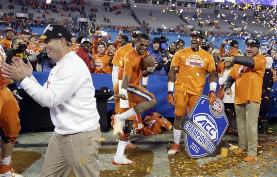 Watson holds a football as coach Dabo Swinney celebrates after Clemson defeated North Carolina 45-37 in the Atlantic Coast Conference championship NCAA college football game in Charlotte N.C. early Sunday Dec. 6 2015