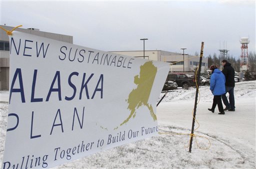 Two people walk past a sign heading into a news conference held by Alaska Gov. Bill Walker on Wednesday Dec. 9 2015 in Anchorage Alaska. Walker unveiled his plan to close a $3.5 billion gap in the state budget including instituting a state income tax