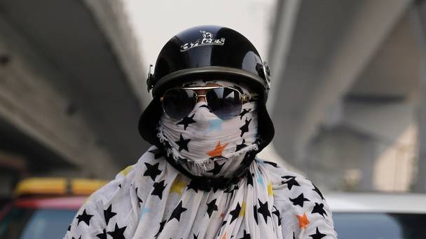 An Indian bike rider wraps up against the pollution in New Delhi