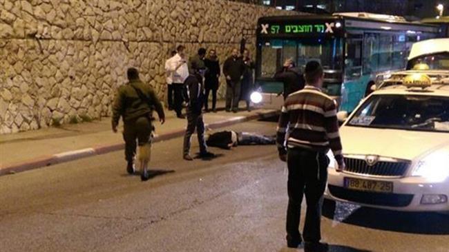 An injured young Palestinian man lies on the ground after being shot by Israeli forces in al Quds