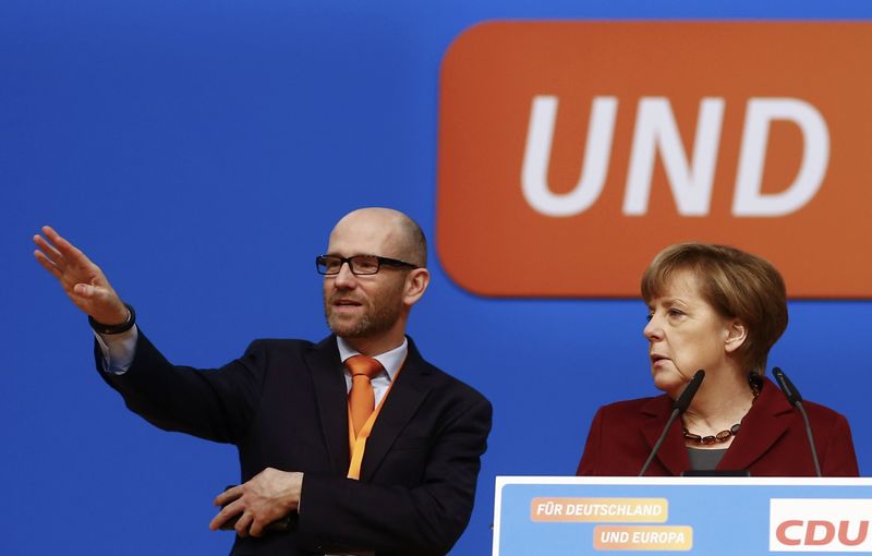 Germany's Christian Democratic Union secretary general Peter Tauber stands on stage with Chancellor Angela Merkel as they tour the venue in Karlsruhe where CDU will hold a two-day congress. – Reuters pic