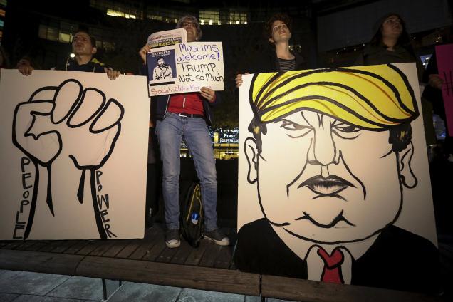 People take part in an anti Donald Trump pro-immigration protest in the Manhattan borough of New York on Thursday