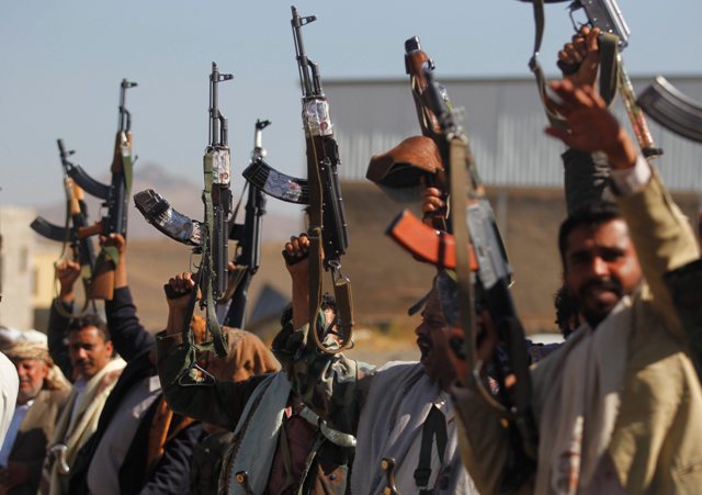 Armed tribesmen hold weapons aloft and shout slogans during a tribal gathering to show support to the Houthi rebels in Sanaa Yemen