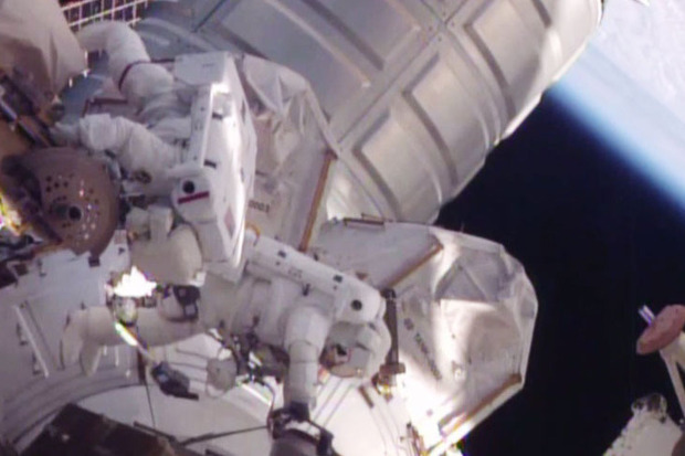 Astronauts Scott Kelly and Tim Kopra work to fix a stalled robotic arm transporter during a Monday spacewalk.  	  		Credit	  		  		NASA