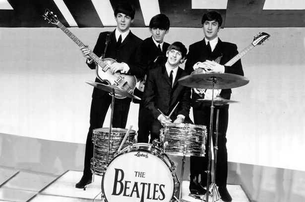 Paul McCartney George Harrison Ringo Starr with his drum kit and John Lennon