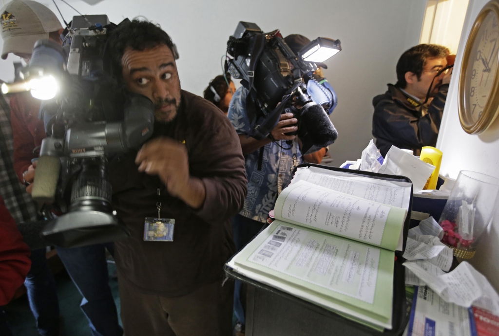 Members of the media crowd into the apartment bedroom of San Bernardino shooting suspects Syed Farook and his wife Tashfeen Malik in Redlands Calif