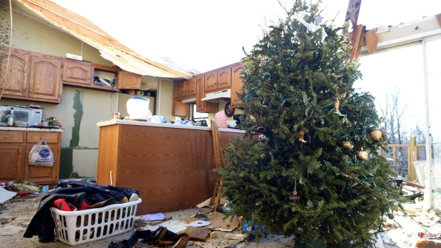 A Christmas tree stands among damage done to a home on Falcon Road in Selmer Tenn. Thursday Dec. 24 2015 after a tornado passed through the area Wednesday evening. At least 14 people have died in storms across the southern U.S. over the past two days