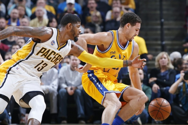 Golden State Warriors Klay Thompson goes for a loose ball against Indiana Pacers Paul George during their game at Bankers Life Fieldhouse on December 8