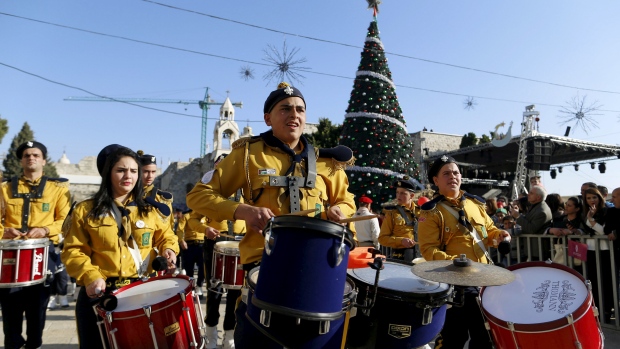 A Palestinian marching band parades during a Christmas procession at Manger Square in the West Bank town of Bethlehem on Christmas Eve