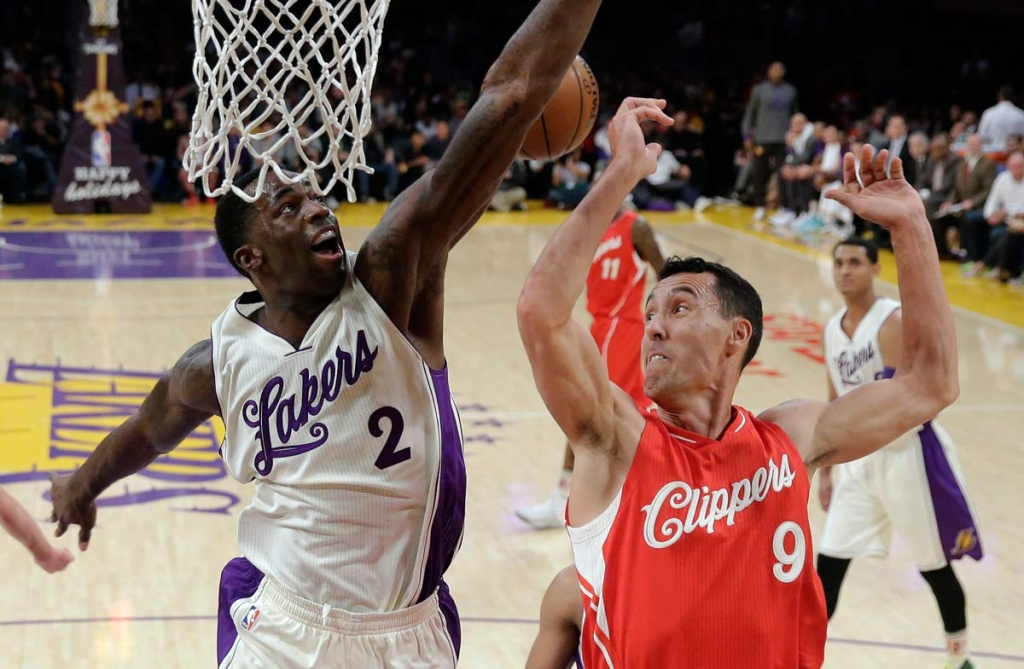 Los Angeles Lakers forward Brandon Bass left blocks a shot by Los Angeles Clippers guard Pablo Prigioni during the first half of an NBA basketball game in Los Angeles Friday Dec. 25 2015