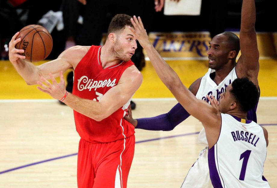 Los Angeles Clippers forward Blake Griffin left passes over Los Angeles Lakers forward Kobe Bryant middle as guard D'Angelo Russell looks on during the first half of an NBA basketball game in Los Angeles Friday Dec. 25 2015