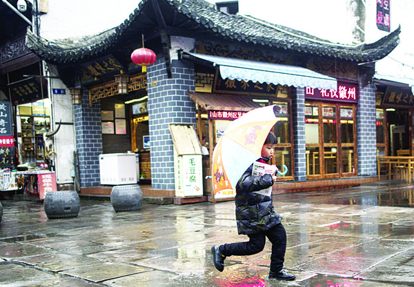 9 shows a child jumping over a puddle on a rainy day in Huangshan city southern Anhui province. China’s consumer inflation rate edged up in November official data showed on Dec 9 while factory gate price falls lingered at