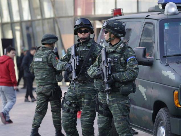 Armed policemen of the Snow Leopard Commando Unit stand guard near a police van at the Sanlitun area a fashionable location for shopping and dining in Beijing China