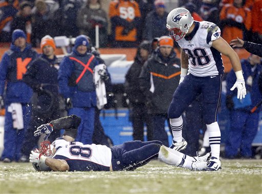 New England Patriots tight end Rob Gronkowski lies injured on the field against the Denver Broncos as teammate tight end Scott Chandler trees to help him up during the second half of an NFL football game Sunday Nov. 29 2015 in Denver. (AP Ph