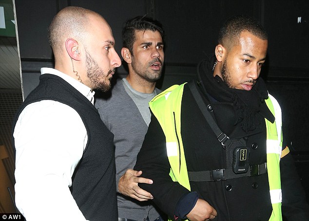 Chelsea striker Diego Costa is escorted out of Libertine nightclub in London on Thursday morning