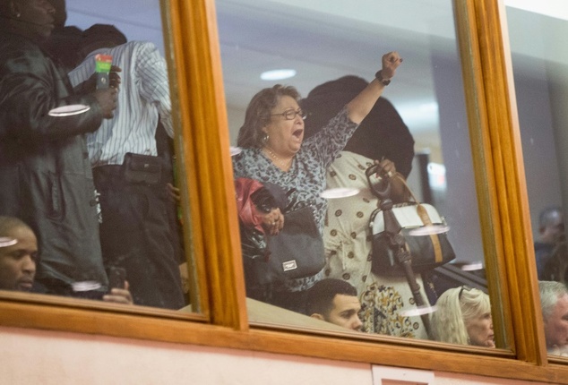 A visitor shouts from the as Chicago Mayor Rahm Emanuel addresses a special session of the city council during which he took responsibility