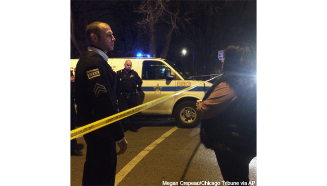 A Chicago police sergeant speaks with a relative of a 19-year-old man killed in a police-involved shooting in the West Garfield Park neighborhood in Chicago on Saturday Dec. 26 2015