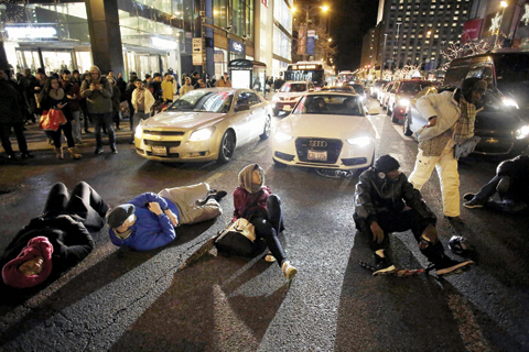 CHICAGO Demonstrators block motorists along Michigan Avenue on Friday as they protest the shooting of Laquan McDonald who was killed by a Chicago police officer. — AFP