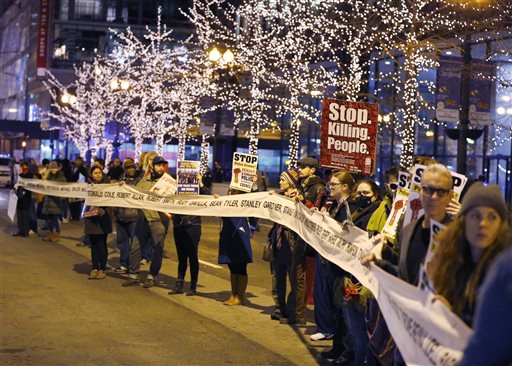 Protesters march through Chicago's Loop on Dec. 10 carrying what organizers say is a banner of names of people tortured and in prison as they also call for Chicago Mayor Rahm Emanuel and Cook County State's Attorney Anita Alvarez to resign in the wake