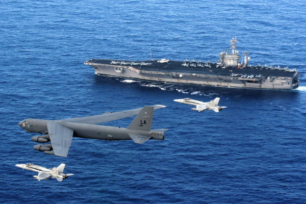 An Air Force B-52 Stratofortress flies past the Navy aircraft carrier USS Nimitz escorted by two Navy F  A-18 Hornets. A B-52 recently flew over contested territory in the South China Sea