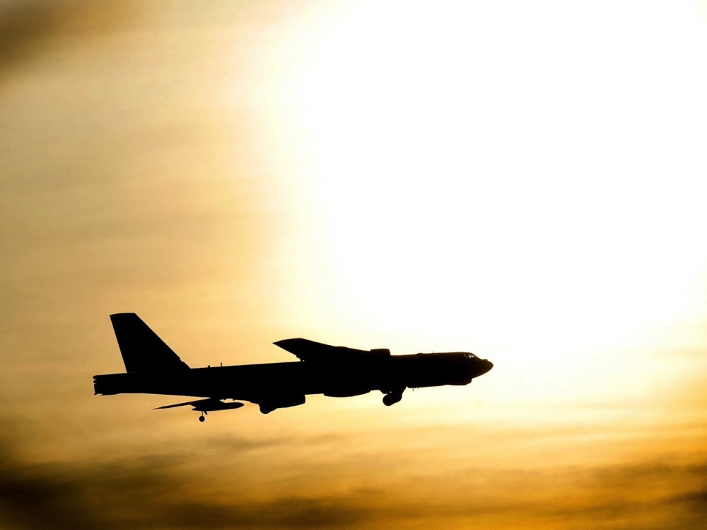 A B-52 Stratofortress flies just under the sun after flying a routine sortie at Minot Air Force Base N.D. Nov. 20 2012. Pilots of the BUFF are required to log certain amounts of hours depending on their skill level per month and to be ready to “OWN I