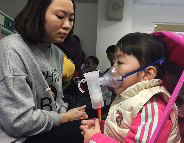 Children receive aerosol therapy on Wednesday at Beijing Children's Hospital which has seen an increase in respiratory system diseases among youngsters since smog hit the capital this week