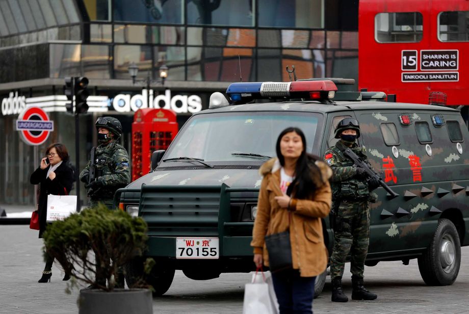 Armed Chinese paramilitary policemen stand guard in the capital city's popular shopping and nightlife area of Sanlitun in Beijing Sunday Dec. 27 2015. China’s rubber-stamp national legislature on Sunday approved the country’s first anti-terrorism