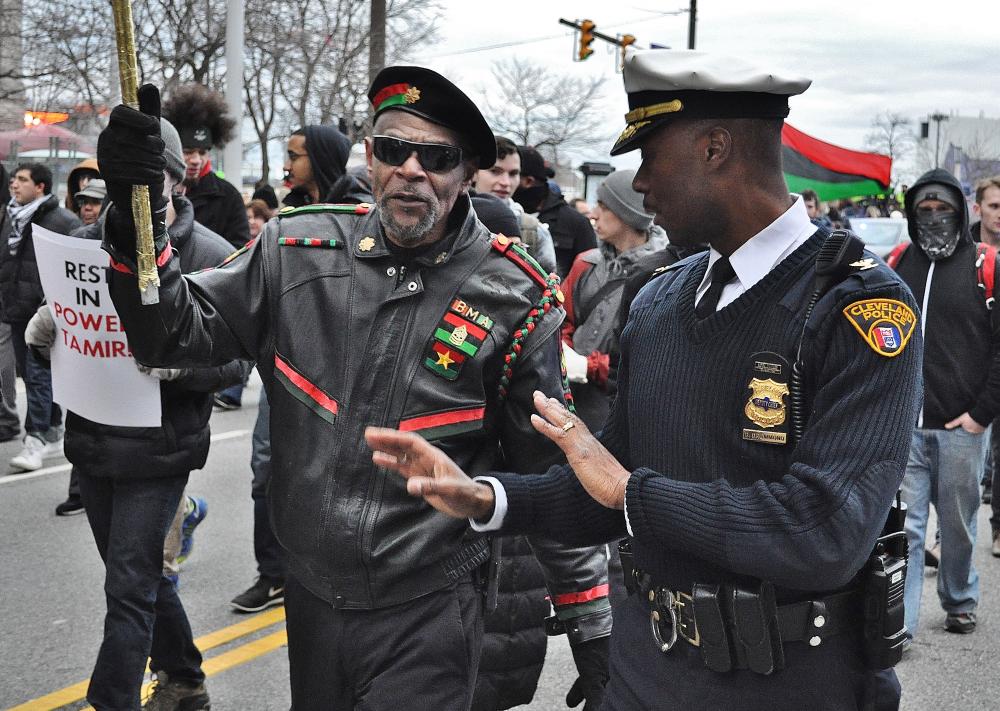 Cleveland Deputy Poluice Chief Dornat'Wayne Drummond speaks with a protester as they march down E. 9th